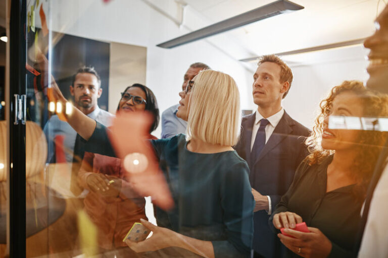 Geschäftsfrau und ihr vielseitiges Team beim Brainstorming